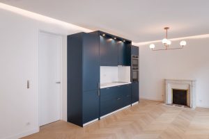 Placard bleu dans chambre blanche avec parquet chevron